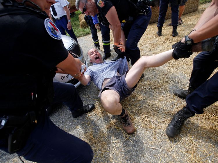 Les policiers portent un manifestant sur la route