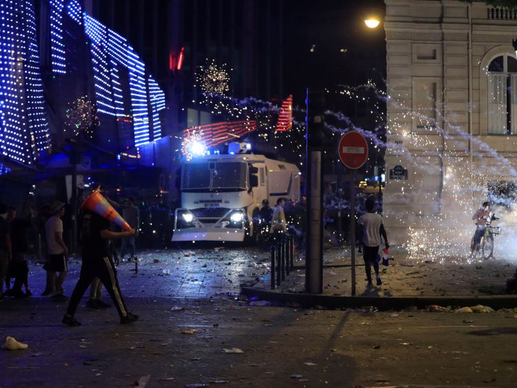 La police anti-émeute CRS française avance au cours des affrontements sur les Champs-Elysées après que la France a remporté la finale de la Coupe du monde.