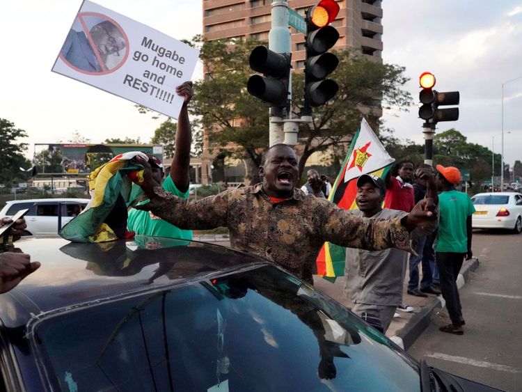 Les gens célèbrent dans les rues après la démission du président du Zimbabwe Robert Mugabe