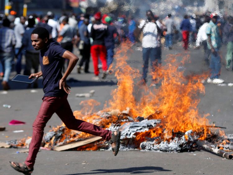 Un homme qui se porte candidat à la défense du parti d'opposition Mouvement pour le changement démocratique (MDC) de Nelson Chamisa brûle des barricades à Harare, au Zimbabwe