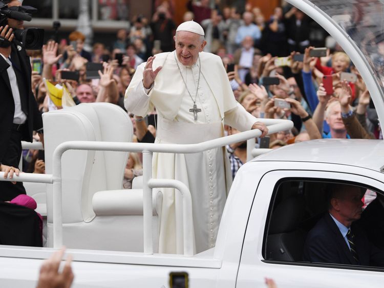 Le pape François accueille le public alors qu'il traverse Dublin dans la Popemobile