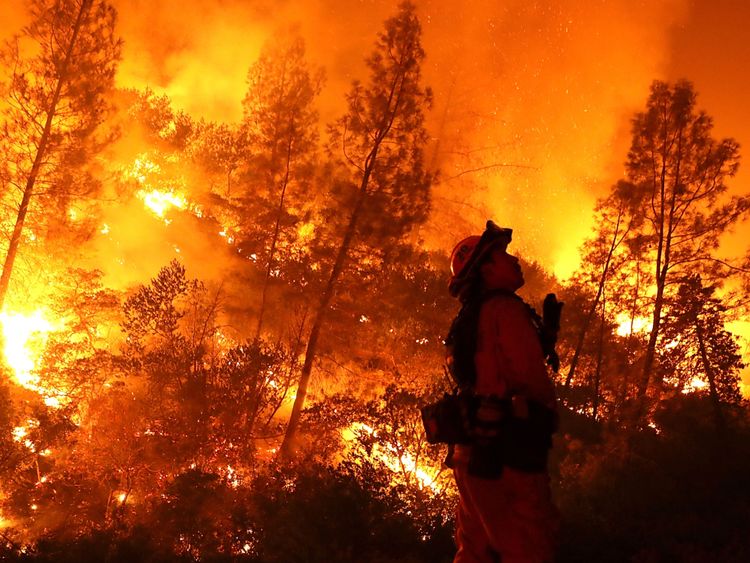 Un pompier surveille un feu arrière tout en luttant contre l'incendie du complexe Medocino près de Lodoga, en Californie
