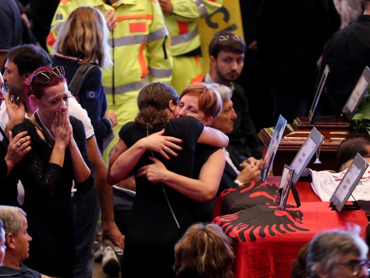 Des familles s'embrassent à côté des cercueils des victimes de l'effondrement du pont de Gênes