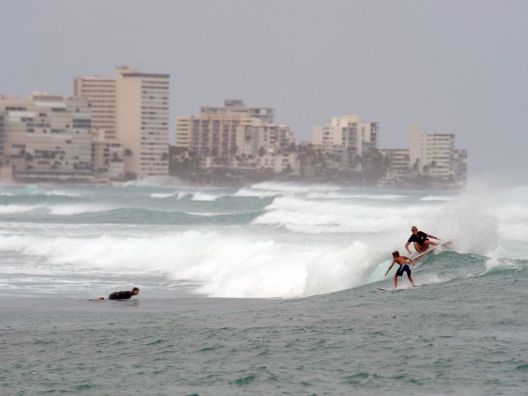 Surfers roulent vers le sud des houles générées par Lane sur la plage de Waikiki, Hawaii 