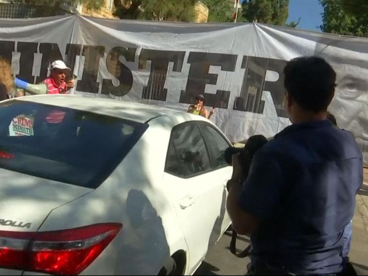 Les manifestants ont tenu la bannière au-dessus de l'entrée de la résidence de M. Netanyahu, alors que la police est arrivée pour l'interroger