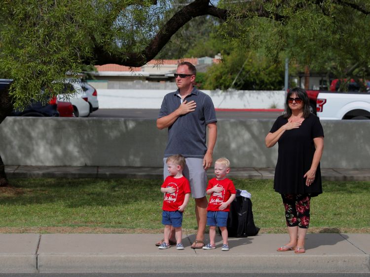 Une famille paie ses respects au passage du cortège