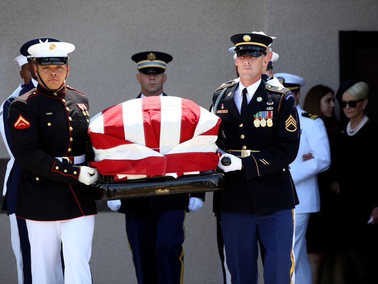La famille McCain suit alors que des porteurs militaires transportent le cercueil du sénateur hors de l'église de Phoenix.