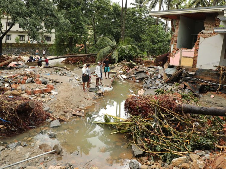 Des résidents indiens observent des maisons détruites par les inondations à Kannappankundu à Kozhikode, dans l'État indien du Kerala