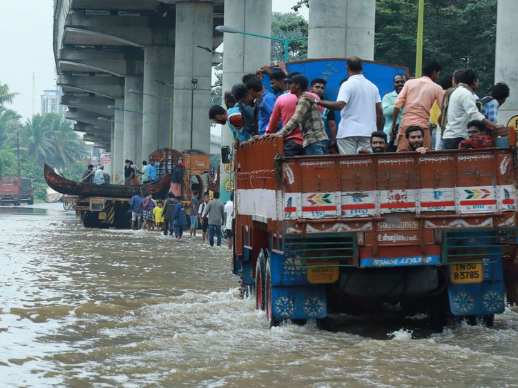 Les navetteurs indiens se déplacent dans un camion pour se rendre dans un endroit plus sûr alors que les inondations ravagent la route nationale 47 dans le district d'Ernakulam à Kochi, dans l'État indien du Kerala