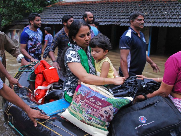 Des volontaires indiens et du personnel de secours évacuent les résidents locaux dans un bateau dans un quartier résidentiel de Kozhikode, dans l'État indien du Kerala
