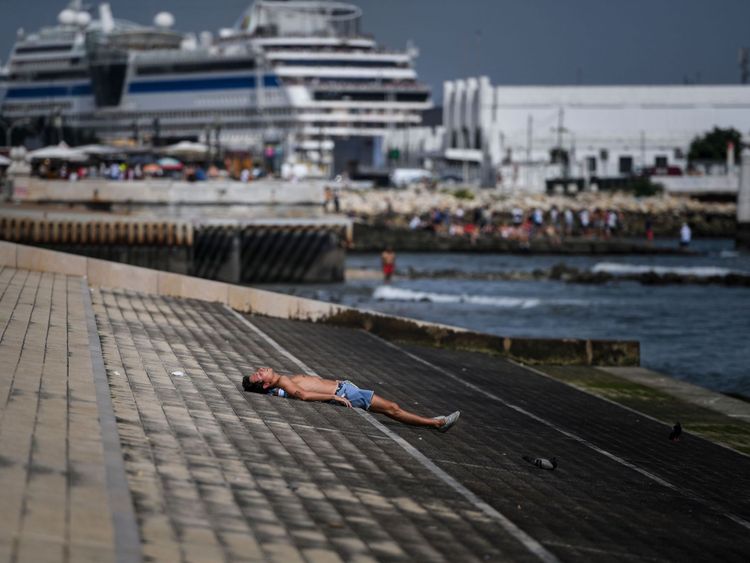 Un homme prend un bain de soleil à Ribeira das Naus à Lisbonne le 3 août 2018. - Deux hommes sont morts de coups de chaleur en Espagne alors que l’Europe traversait une vague de chaleur record, des températures atteignant 45 degrés Celsius dans certaines régions. en vue dans les prochains jours. La température la plus élevée jamais enregistrée en Europe était de 48 degrés à Athènes en 1977, suivie de près par 47,3 à Amareleja au Portugal en 2003 et à Montoro en Espagne l’an dernier. (Photo de PATRICIA DE 
