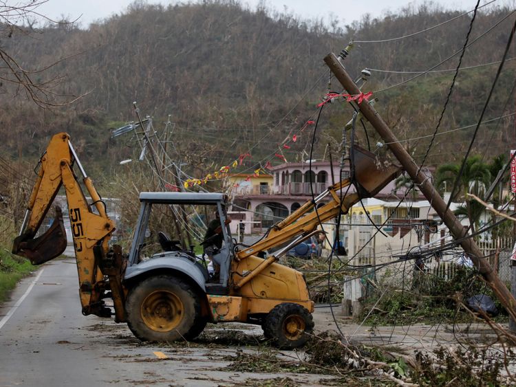 Un travailleur enlève les lignes électriques endommagées à Yabucoa, à Porto Rico