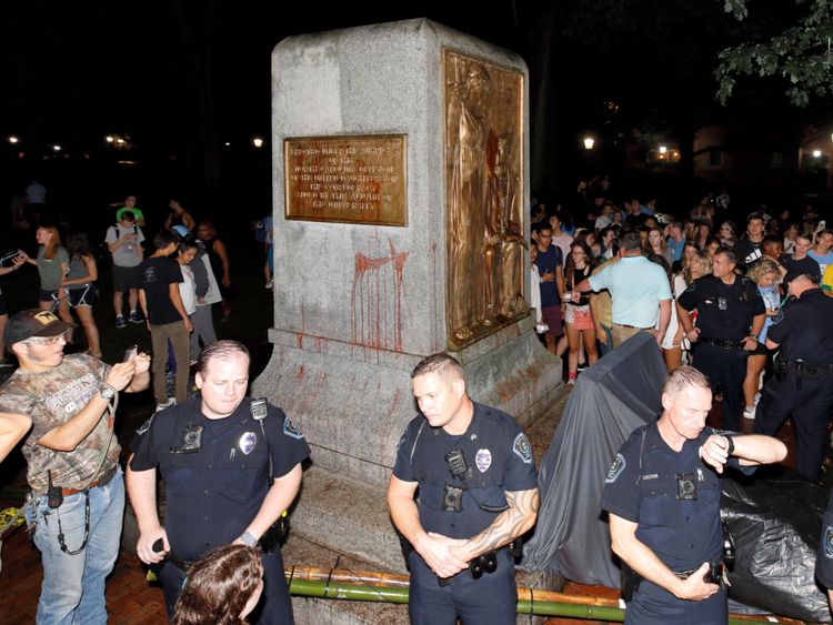 La police de l'Université de Caroline du Nord entoure la statue renversée d'un soldat confédéré surnommé Silent Sam sur le campus de l'école après une manifestation pour son enlèvement à Chapel Hill, en Caroline du Nord, aux États-Unis, le 20 août 2018. REUTERS / Jonathan Drake