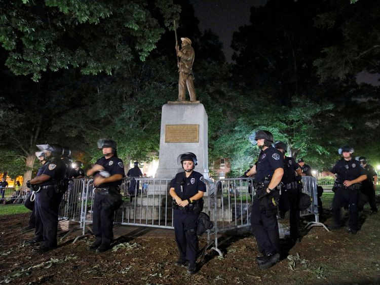 La police en tenue anti-émeute garde une statue d'un soldat confédéré surnommé Silent Sam sur le campus de l'Université de Caroline du Nord lors d'une manifestation pour son enlèvement à Chapel Hill, en Caroline du Nord, le 22 août 2017. REUTERS / Jonathan Drake JOURNÉE