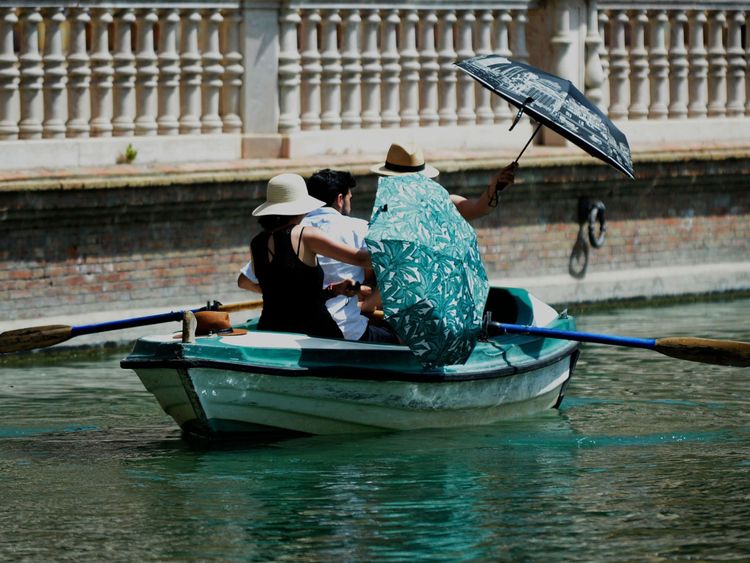 Les gens à l'ombre des parasols lors d'une promenade en bateau à Séville