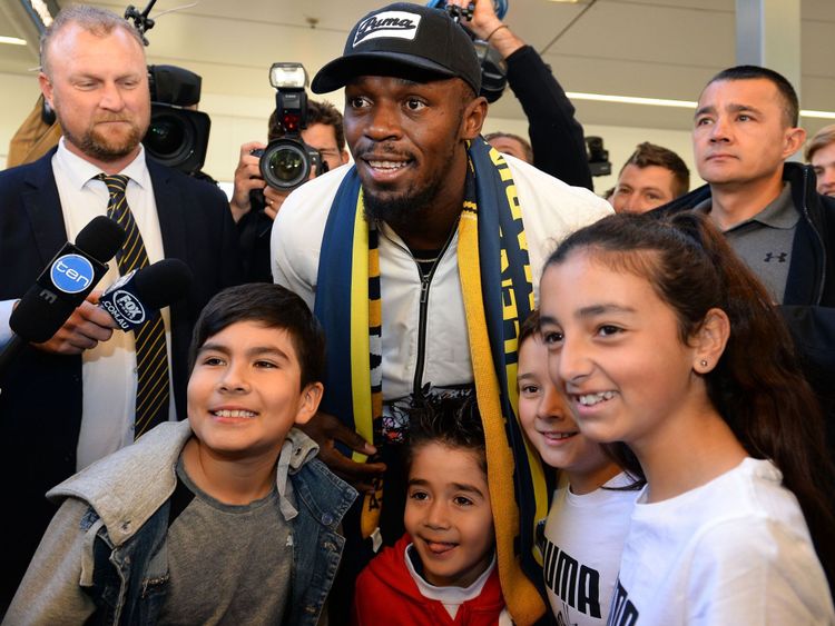 Usain Bolt pose pour des photos avec des fans à son arrivée à l'aéroport international de Sydney