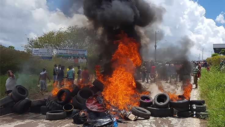 Les habitants de la ville frontalière brésilienne de Pacaraima brûlent des pneus et des effets personnels d'immigrants vénézuéliens après avoir attaqué leurs deux principaux camps de fortune