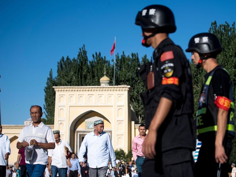 La police patrouille alors que des musulmans quittent la mosquée Id Kah après la prière du matin sur l’Eid al-Fitr dans la vieille ville de Kashgar, dans la région du Xinjiang en Chine