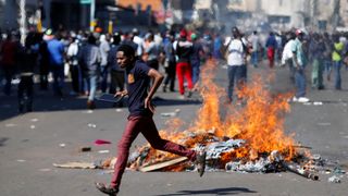 Un homme qui se porte candidat à la défense du parti d'opposition Mouvement pour le changement démocratique (MDC) de Nelson Chamisa brûle des barricades à Harare, au Zimbabwe