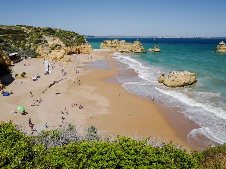 Les gens apprécient le temps chaud sur la plage Dona Ana à Lagos le 18 avril 2018 dans la région d'Algarve, au sud du Portugal