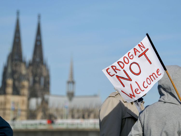 Une femme marche avec une bannière en lisant Erdogan not Welcome & # 39; et la cathédrale de Cologne en arrière-plan avant une manifestation sur le thème Erdogan pas les bienvenus & # 39; avant la visite du président turc à Cologne, le 29 septembre 2018