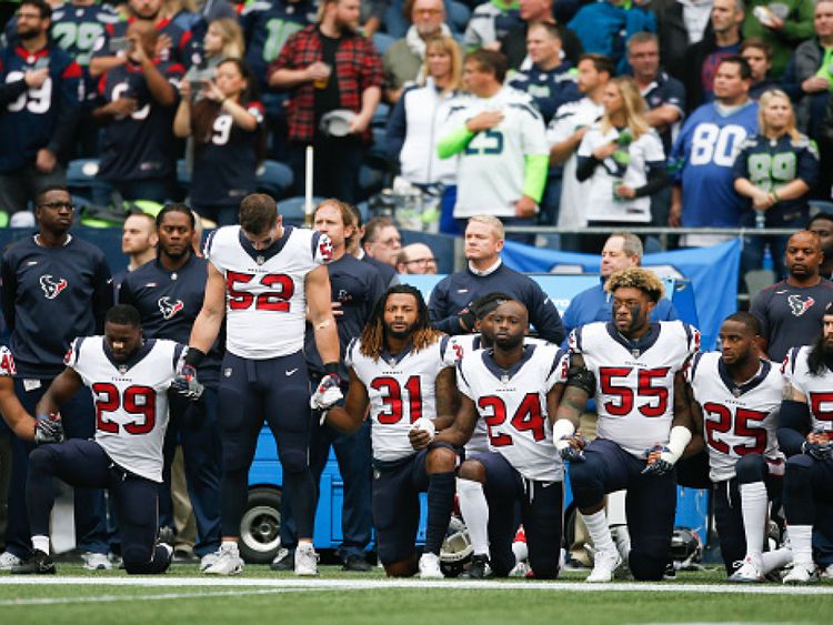 Les membres du Houston Texas se mettent à genoux avant leurs matchs aux Seahawks de Seattle