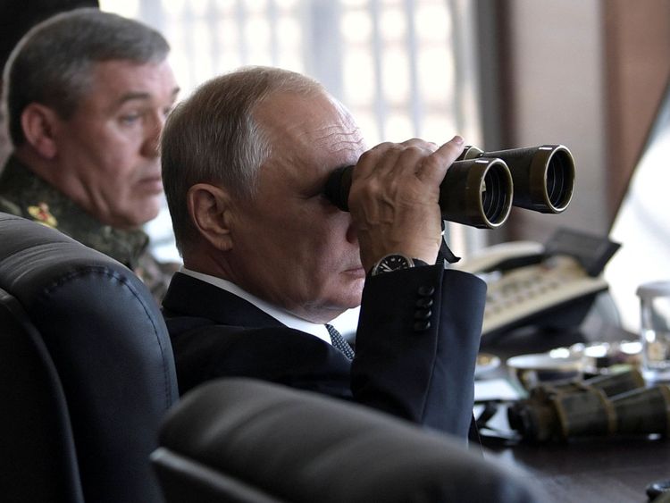 Le président russe Vladimir Poutine utilise une paire de jumelles en regardant les jeux de guerre Vostok-2018 (Est-2018)