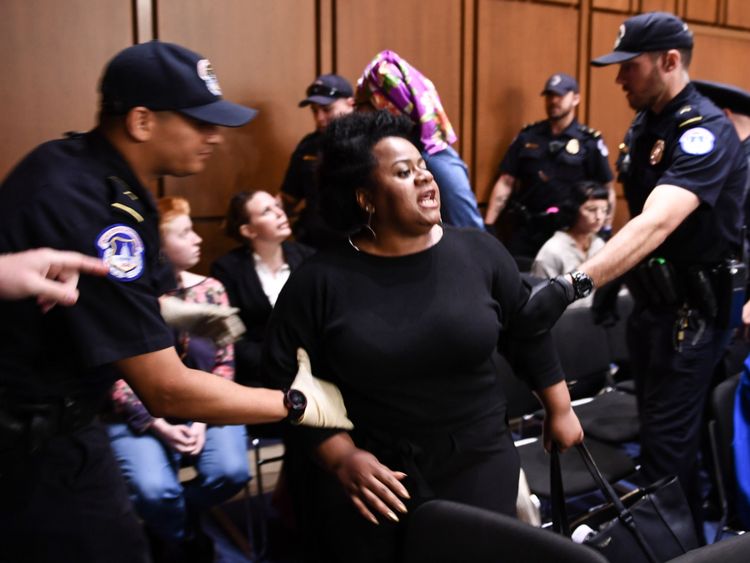 Un manifestant est emmené loin de l'audience de confirmation
