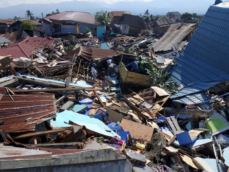 À la suite d'un tremblement de terre et d'un tsunami à Palu, dans le Sulawesi central, des personnes fouillent des débris dans un quartier résidentiel