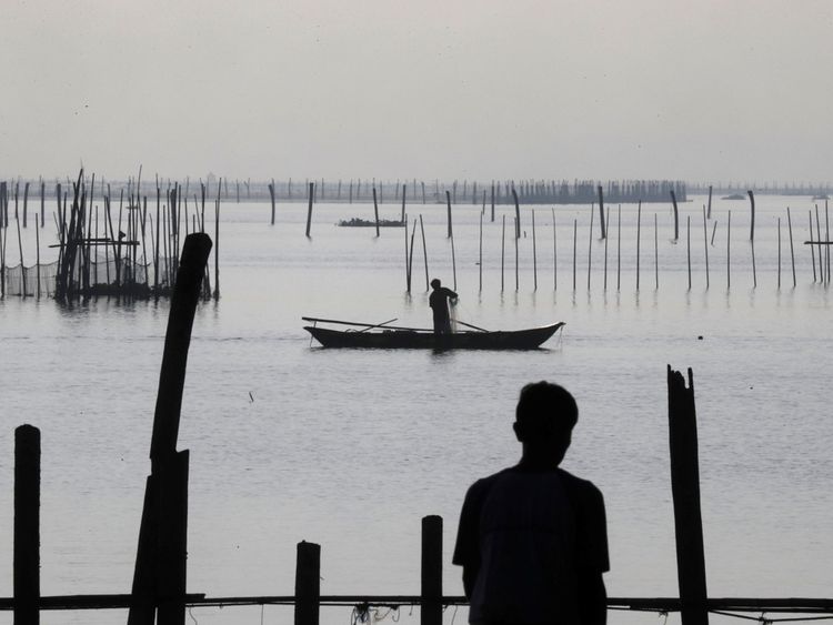 Un ouvrier récupère le filet dans un enclos à poisson à Luzon avant l'arrivée du typhon
