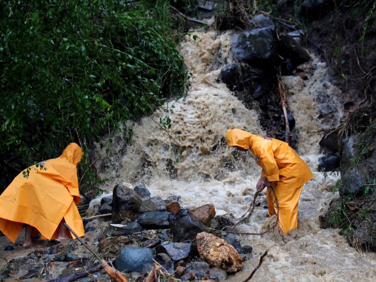 Des employés du gouvernement dégagent une route partiellement endommagée après le passage du typhon Mangkhut sur l'île principale de Luzon, aux Philippines