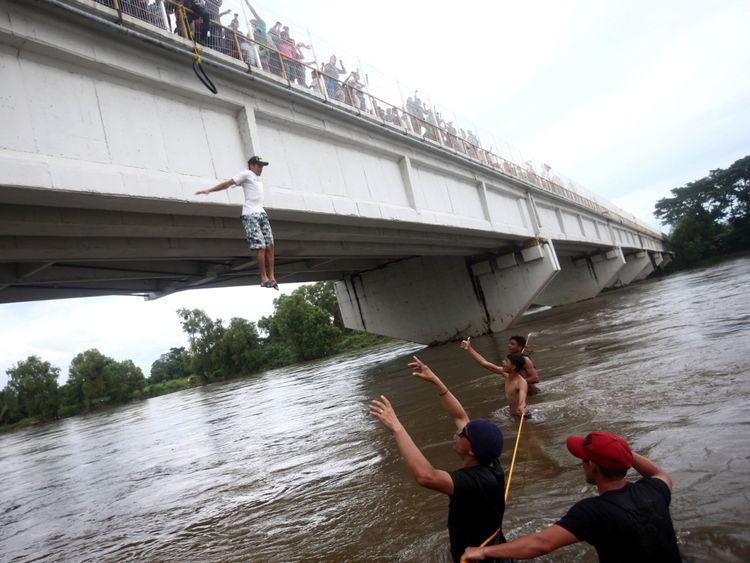 Un Hondurien saute d'un pont pour éviter un poste de contrôle à la frontière entre le Guatemala et le Mexique