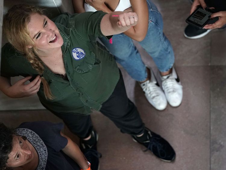 Amy Schumer attend d'être emmenée lors d'une manifestation contre le candidat de la Cour suprême Brett Kavanaugh.  