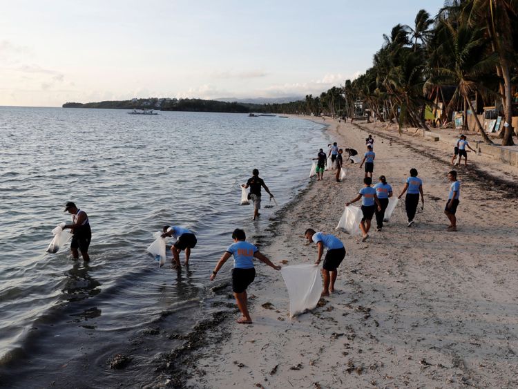 Un policier ramasse des ordures sur la plage de Bulabog à Boracay