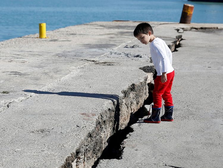 Un enfant regarde la jetée endommagée du port de Zakynthos, à la suite du tremblement de terre survenu sur l'île de Zakynthos, en Grèce, le 26 octobre 2018. REUTERS / Costas Baltas