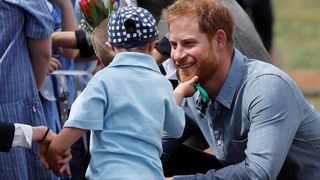 Le prince Harry et Meghan, la duchesse de Sussex, discutent avec Luke Vincent, 5 ans, après leur arrivée à l'aéroport de Dubbo
