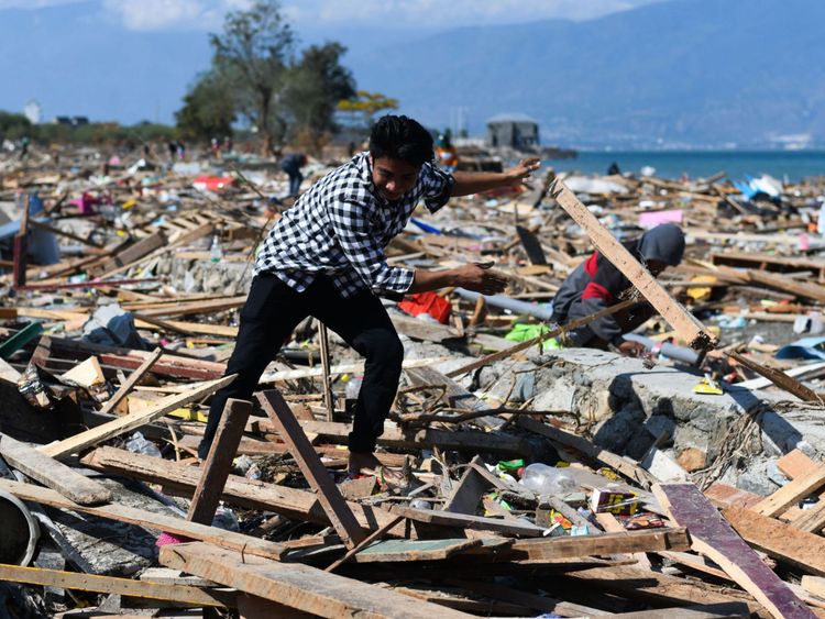 Un survivant passe à travers les débris de Palu