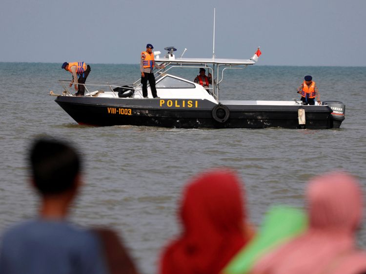Les gens regardent les membres de l'équipe de secours sur un bateau avant de se diriger vers le Lion Air, vol JT610, lieu de l'accident en mer