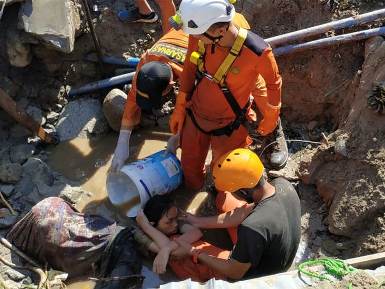 Les sauveteurs aident un enfant pris au piège dans les décombres de Palu, mais la machinerie lourde est rare