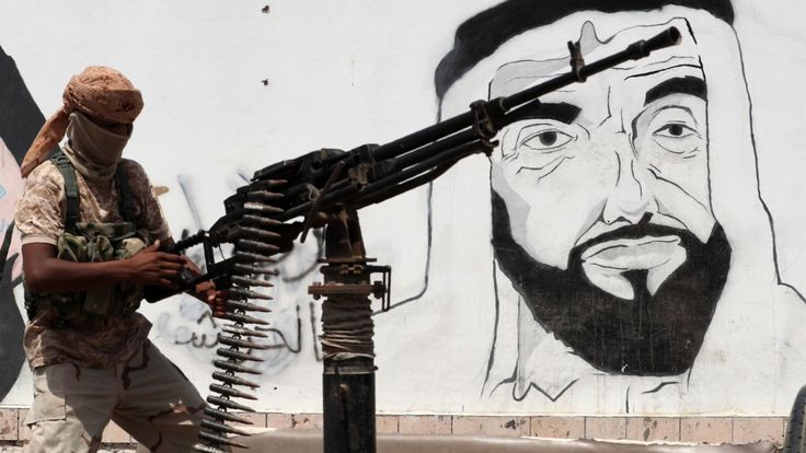 Un soldat progouvernemental en passant devant une peinture murale du défunt fondateur des Emirats Arabes Unis, Cheikh Zayed bin Sultan al-Nahyan, dans la ville de Mukalla