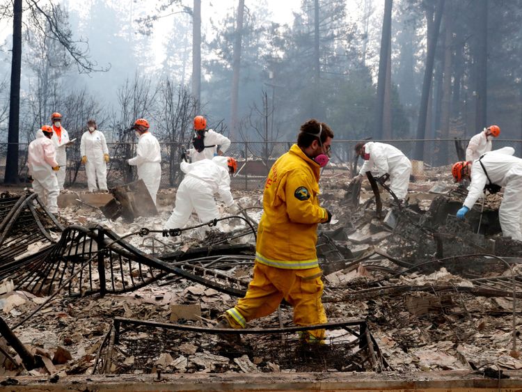Des pompiers et des membres d'une équipe de recherche et de sauvetage bénévoles s'approchent d'une maison détruite par l'incendie du camp à Paradise, Californie, États-Unis, le 13 novembre 2018. REUTERS / Terray Sylvester