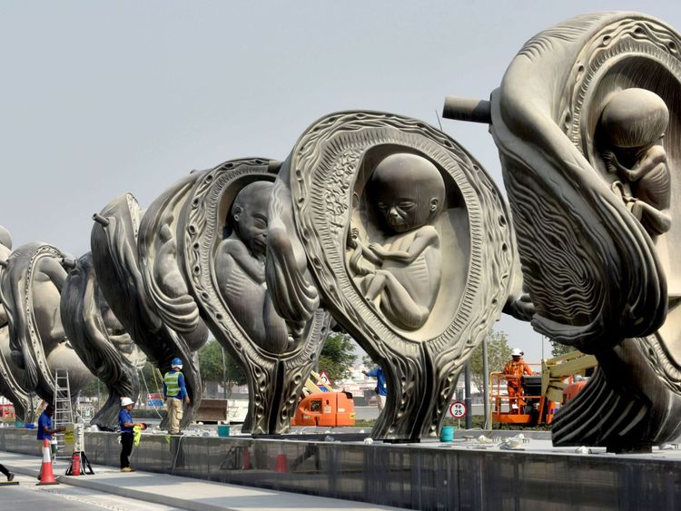 Les ouvriers travaillent sur "Le voyage miraculeux", une installation artistique de l'artiste Damien Hirst devant le centre médical et de recherche Sidra à Doha, la capitale du Qatar, le jour de leur dévoilement le 10 octobre 2018.