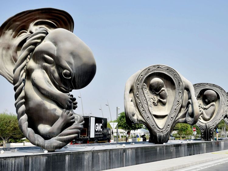 Les ouvriers travaillent sur "Le voyage miraculeux", une installation artistique de l'artiste Damien Hirst devant le centre médical et de recherche Sidra à Doha, la capitale du Qatar, le jour de leur dévoilement le 10 octobre 2018.