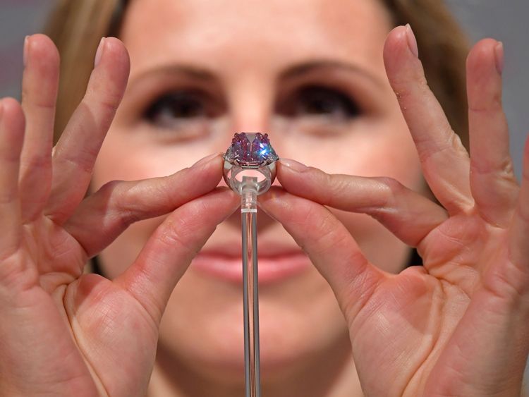 Rachel Evans-Omeyer, spécialiste en joaillerie chez Christie, pose avec un diamant Fancy Vivid Pink de 18,96 carats avant d’être mise aux enchères en novembre à Genève, chez Christie à Londres, au Royaume-Uni, le 25 septembre 2018. REUTERS / Toby Melville