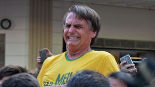 Le candidat de la droite brésilienne Jair Bolsonaro à la présidentielle fait des gestes après avoir été poignardé au ventre