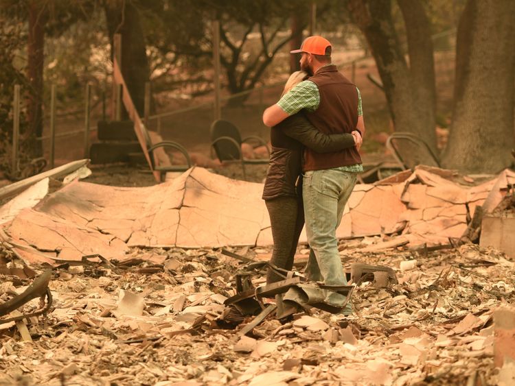 Chris et Nancy Brown s'embrassent en regardant les restes de leur maison incendiée au paradis