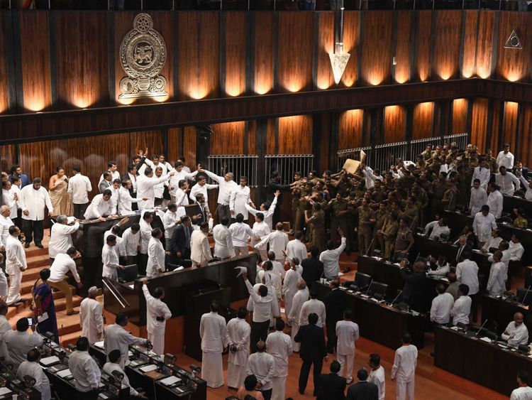 La police sri-lankaise (R) se réunit pour escorter le président du Parlement, Karu Jayasuriya, dans la salle de réunion, alors que des législateurs rivaux (L) occupent le siège du président à Colombo le 16 novembre 2018. - Le président du Parlement de Sri Lanka a demandé la police la protection en tant que violence revint à la législature pour une deuxième journée le 16 novembre, les factions rivales dans la crise constitutionnelle de l'île ne montrant aucun signe de recul. Un groupe de législateurs occupa la présidence du président Karu Jayasuriya pendant 50 minutes.