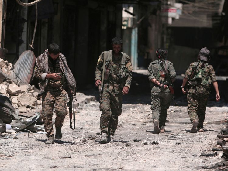 Des combattants des Forces démocratiques syriennes (SDF) traversent Manbij après avoir vaincu l'EI en 2016