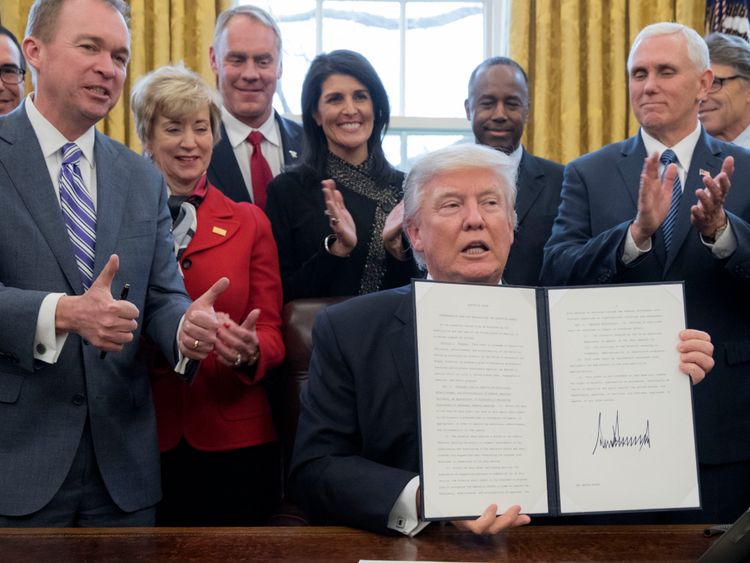 Mick Mulvaney (à gauche) dans le bureau ovale avec le président Trump après avoir signé un ordre exécutif 