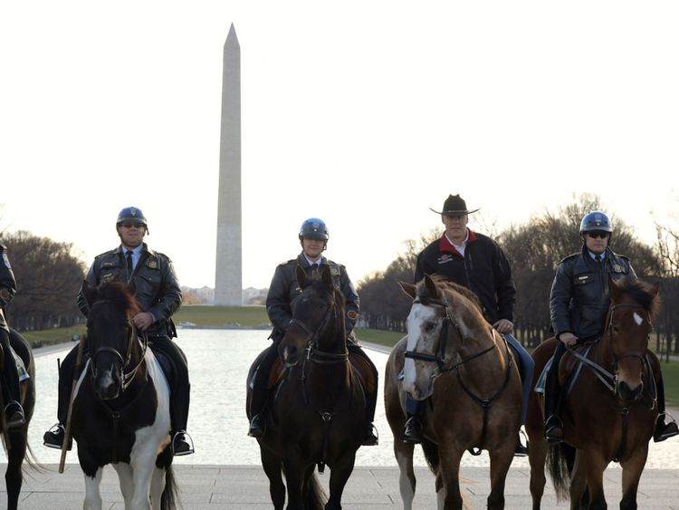Ryan Zinke, deuxième à partir de la droite, monte à cheval tout en se préparant pour son premier jour de travail